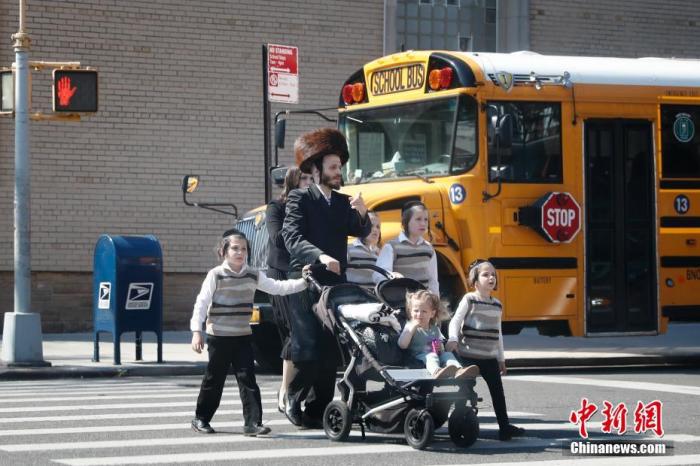 资料图：当地时间5月17日，民众从美国纽约市犹太社区的一所学校外经过。 <a target=&apos;_blank&apos; href=&apos;http://www.chinanews.com/&apos;><p align=
