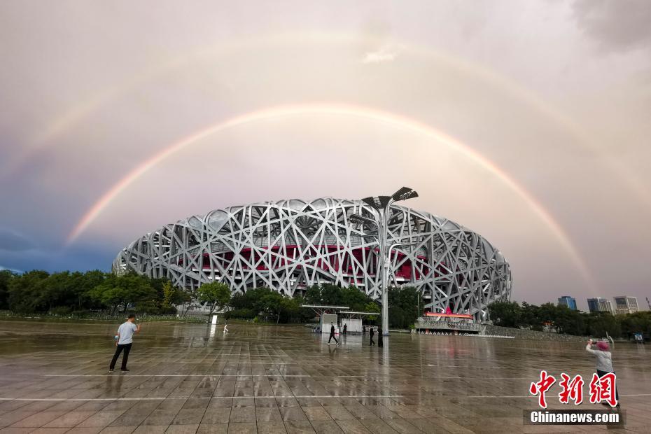 雨后彩虹跨越“鸟巢”(国家体育场)，市民驻足欣赏拍照。<a target=&apos;_blank&apos; href=&apos;/&apos;><p align=