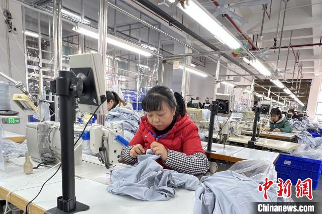 毕节市晶煌制衣有限公司生产车间工人赶制服装。　贵州省投资促进局供图